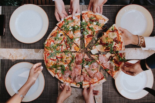 A picture of people sharing a pizza